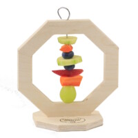 Das Foto zeigt einen Snackständer für Hamster aus Holz. Auf dem Spieß sind Trauben, Karotten und Heidelbeeren aufgespießt